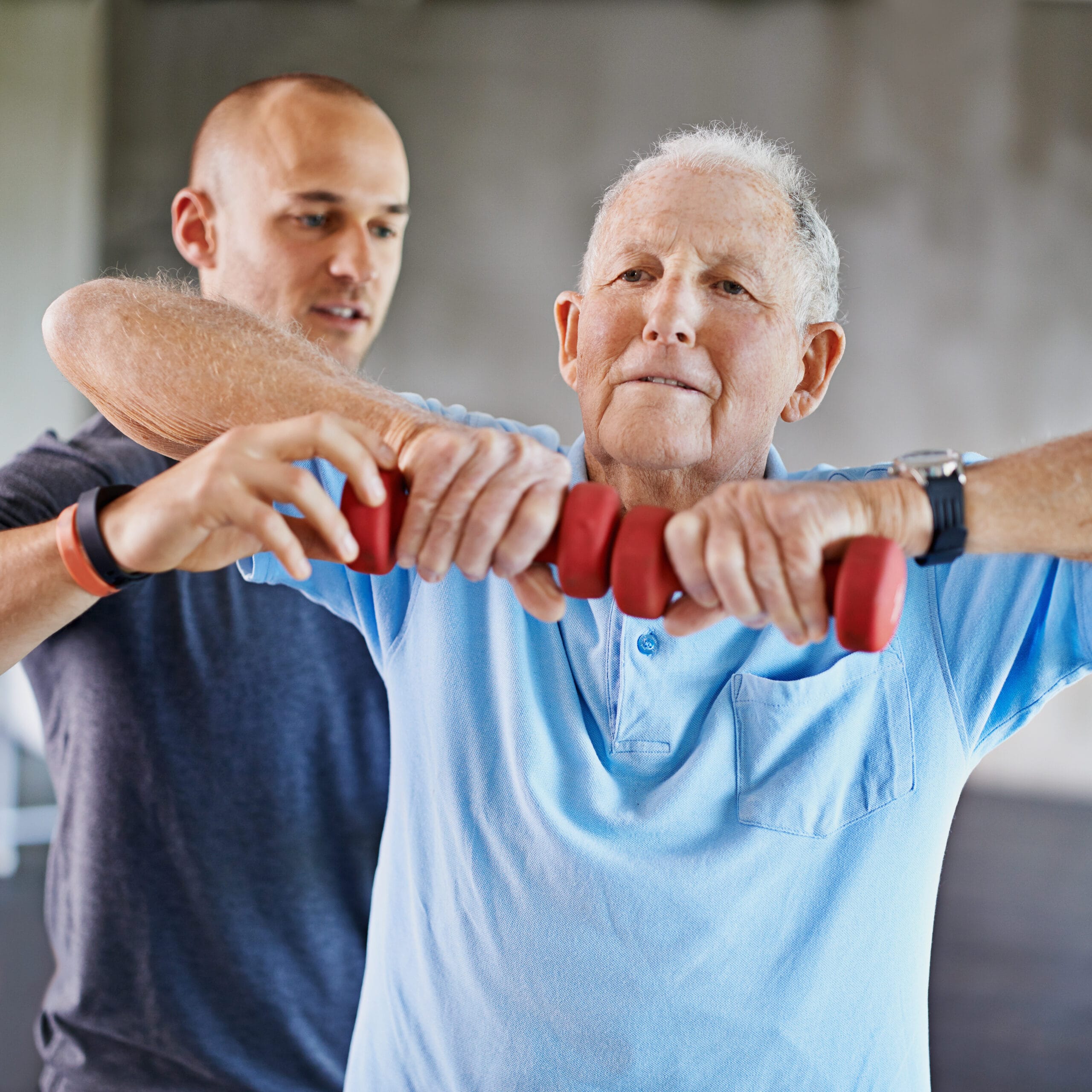 Shot of a senior man working out with the help of a trainer.