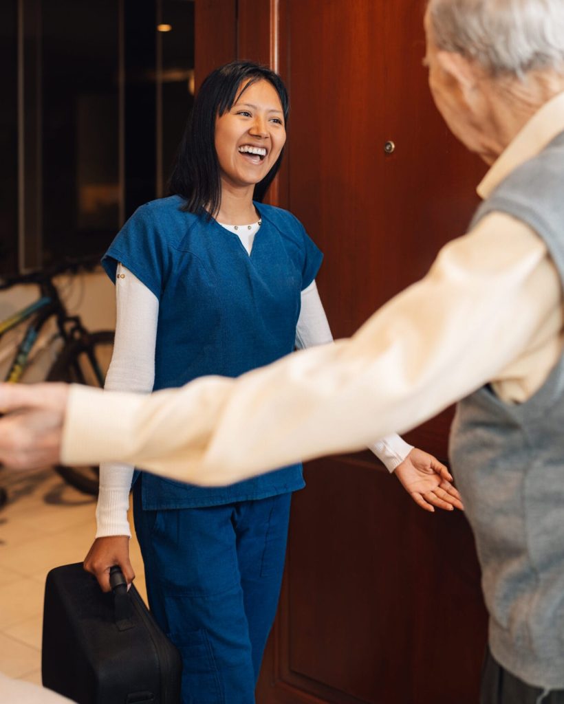 Happy health worker arriving at a house to visiting an old man