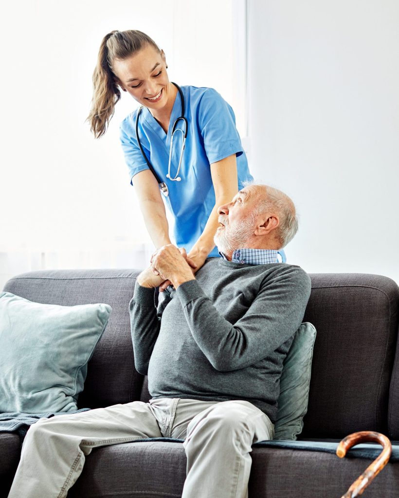 Doctor or nurse caregiver with senior man at home or nursing home